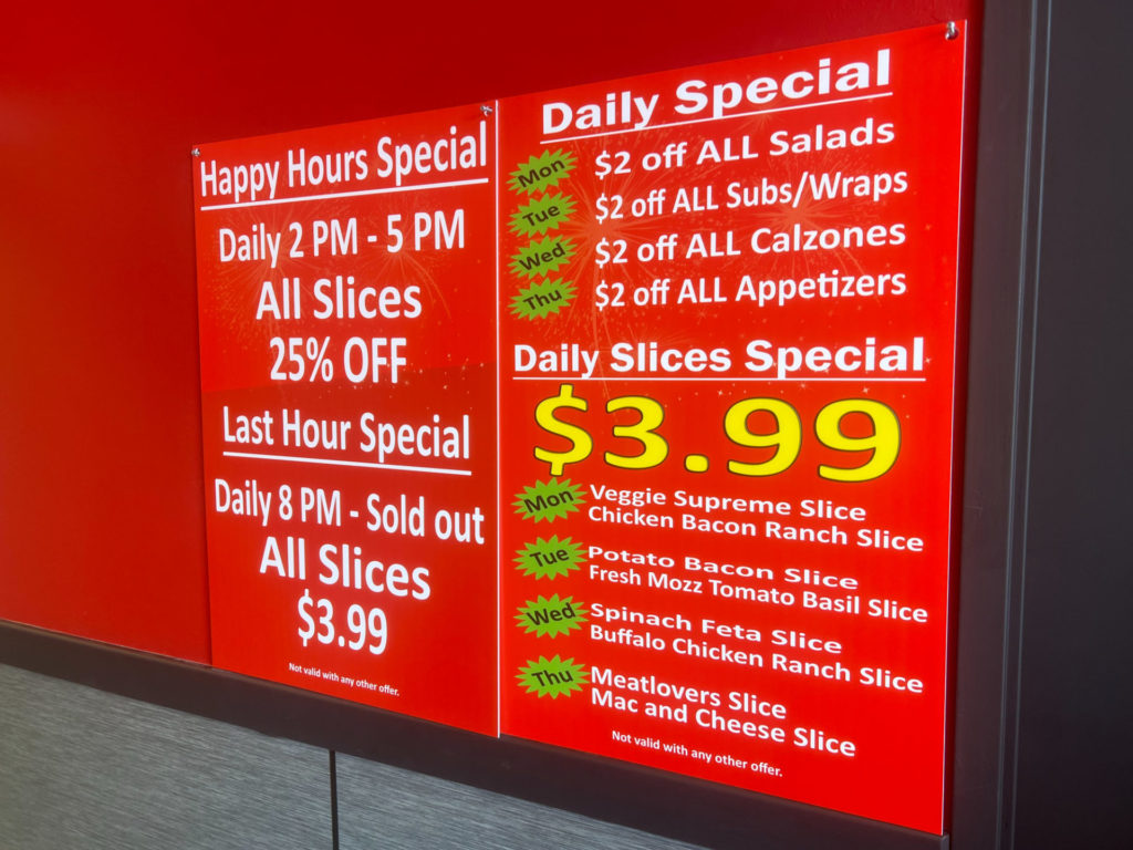 A red menu listing the happy hour specials and daily specials.